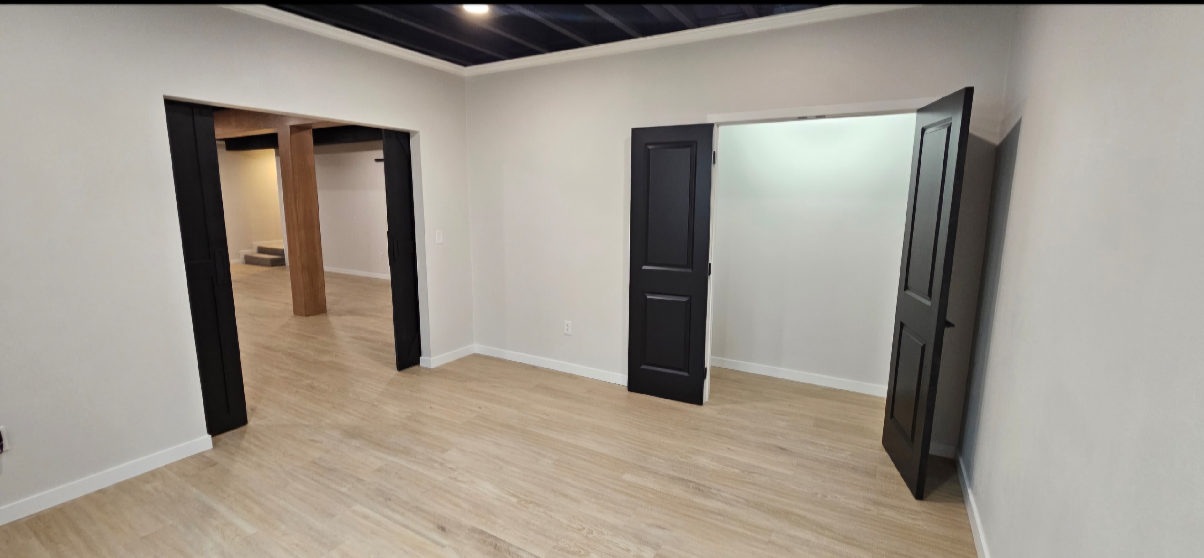 Finished basement hallway with white trim and open doorways.
